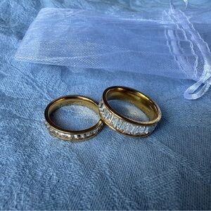 Two gold tone rings with faux diamonds